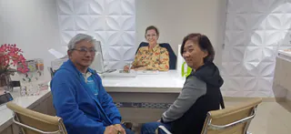 Maira Requena em atendimento com paciente e acompanhante no consultório